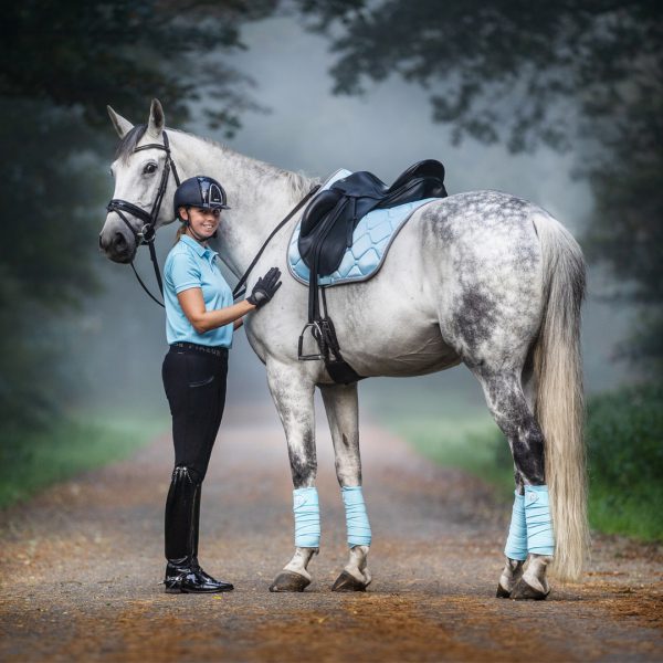 standfoto met paard en amazone in lichtblauwe set